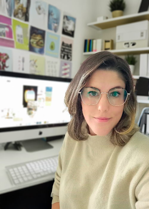 Person sitting at a desk in an office with a computer and decor.